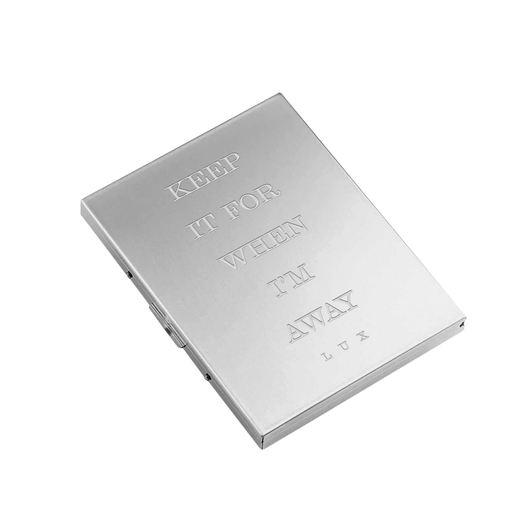 Silver metal box with engraved text reading 'Keep it for when I'm Away - Lux' across the front