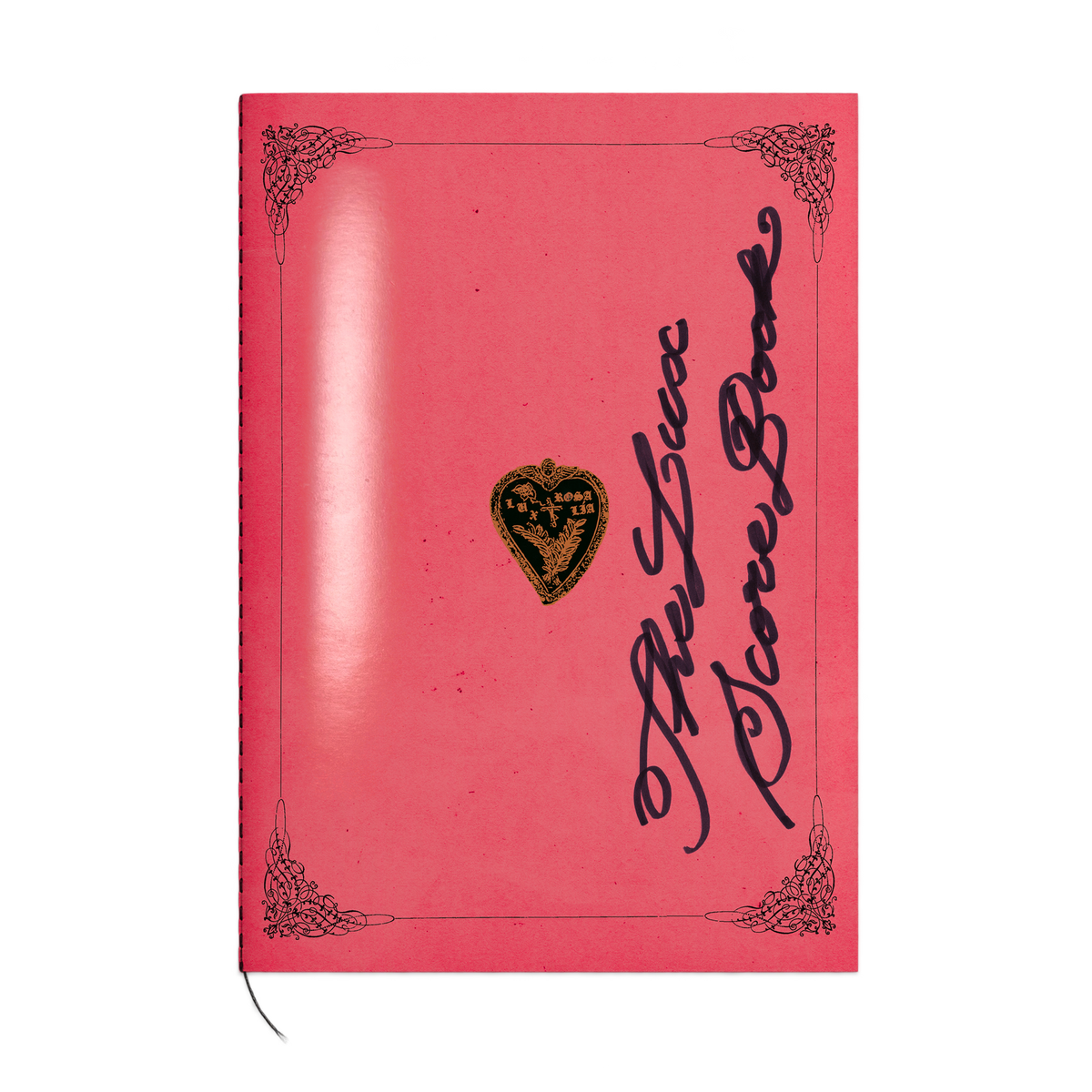 A pink hardcover notebook with black gothic-style script reading 'The Love Score Book' and an ornate black border, featuring a small gold heart emblem with 'Love' in the center. A thin black ribbon bookmark is visible at the bottom left.